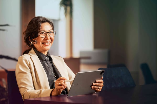 office-woman-tablet-pen-glasses-smiling-looking-ahead-dstny_LR