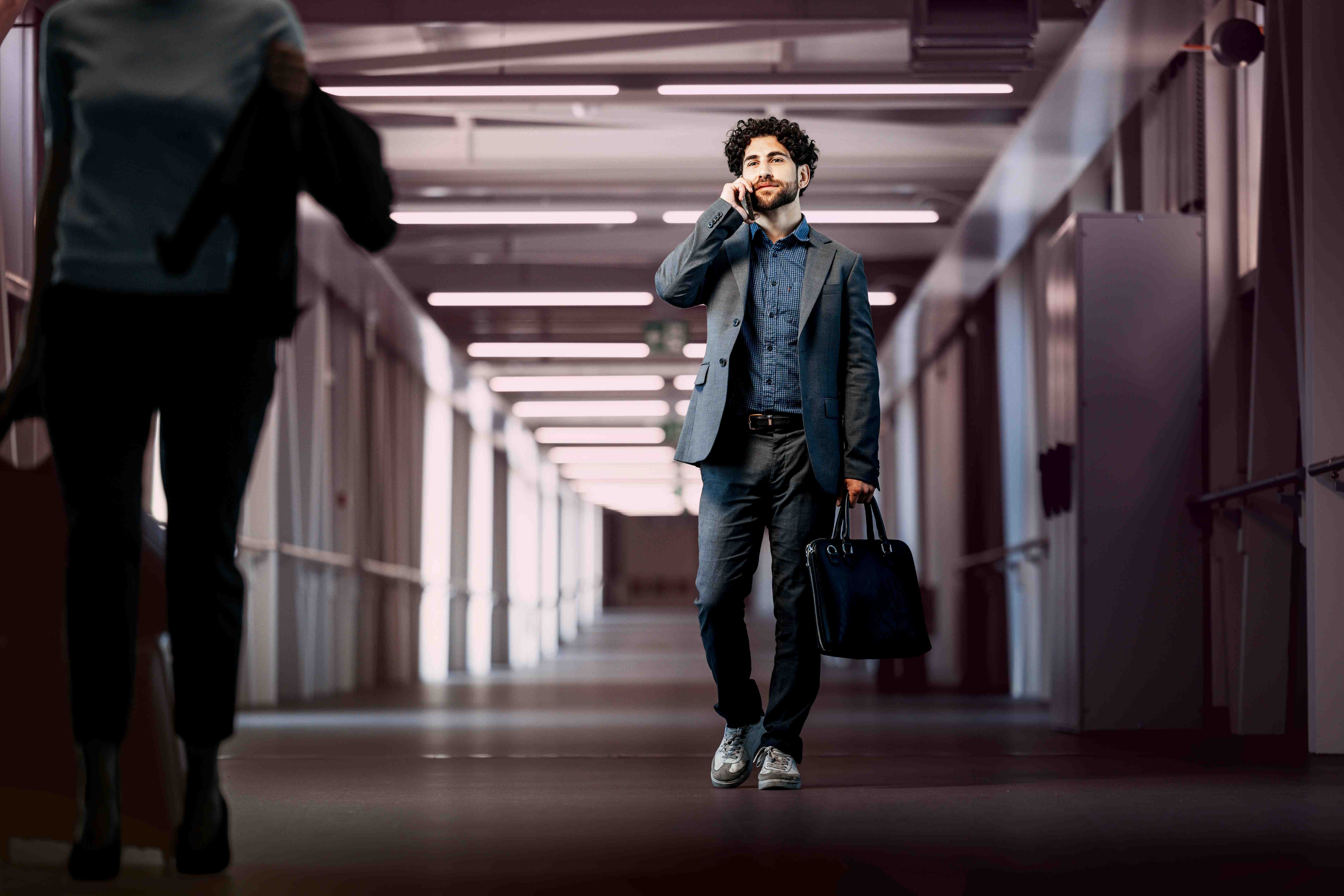 walkway-man-latino-mobile-phone-call-walking-suitcase-suit-dstny_LR